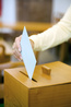 Frau bei Wahl mit Stimmzettel und Wahlurne