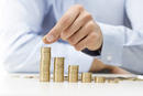 Savings, male hand stacking gold coins