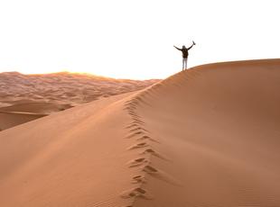 lonely-person-standing-top-sand-dune-desert-sunset