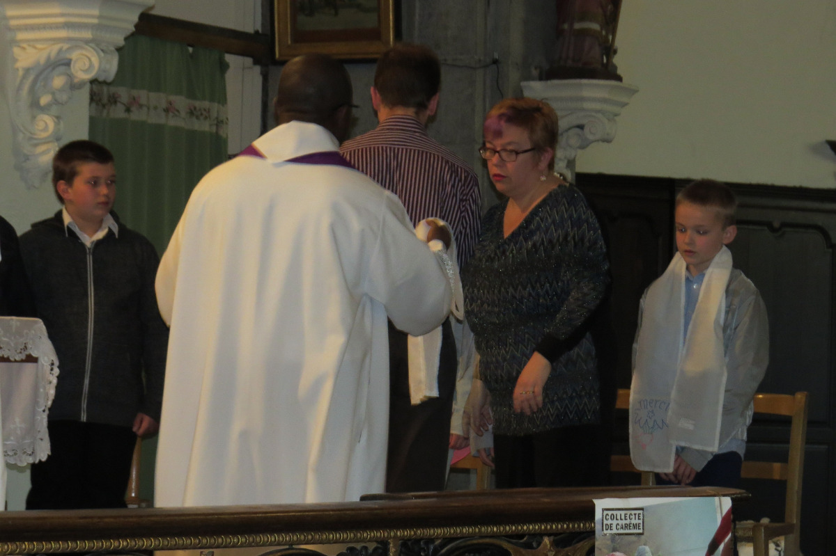 Le prêtre remet aux catéchistes les écharpes blanches