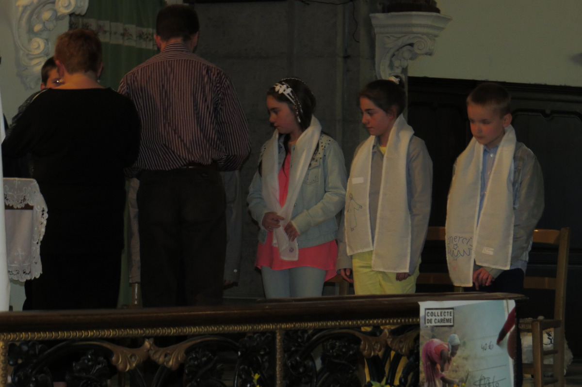 Les enfants reçoivent les écharpes des mains des catéchistes qui les ont guidés.