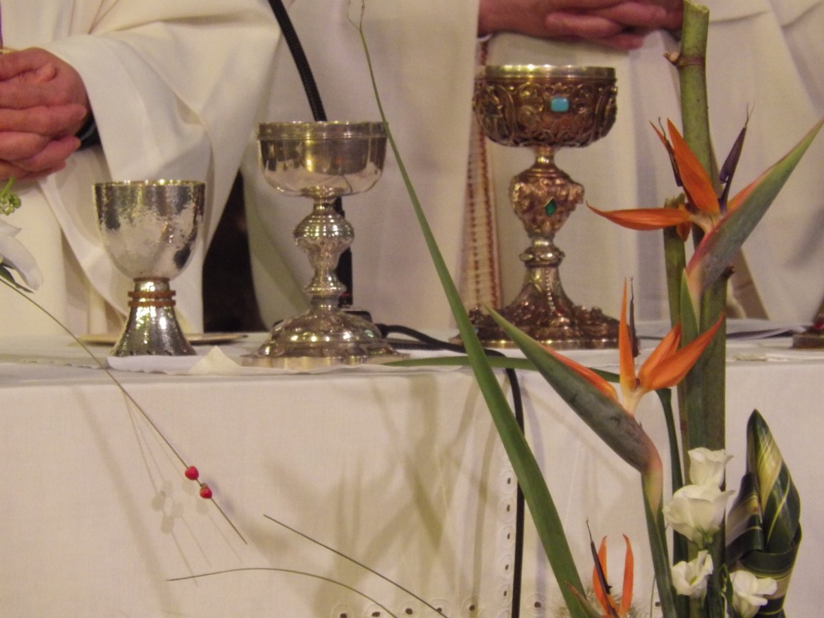 Calice et ciboires sur la table eucharistique.