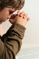 young boy praying vertical