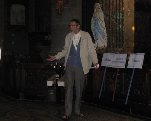 Georges qui fait partie du Tiers-Ordre franciscain, présente Saint François aux adultes rassemblés dans l'église