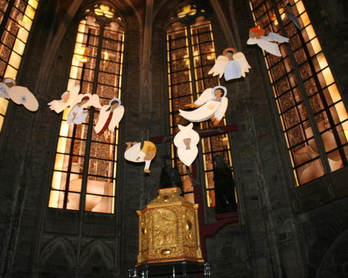 Au-dessus du tabernacle et devant le calvaire, volent de nombreux anges...