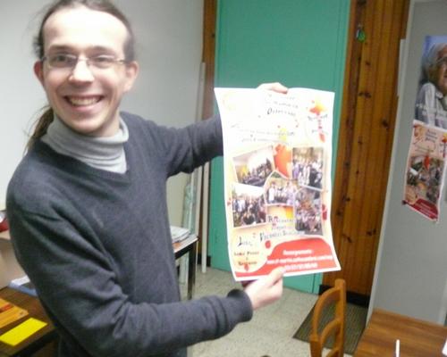 Jean-François, animateur, présente l'affiche "pub" de l'aumônerie