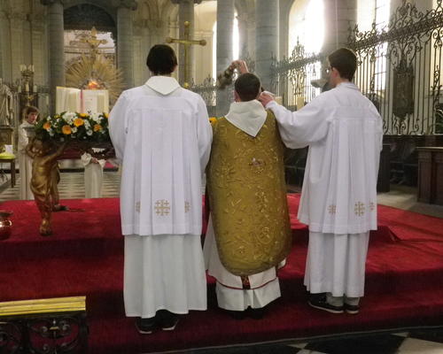 Le père Bernard Descarpentries, qui a revêtu une dalmatique et une superbe chasuble romaine dorée, encense l'autel, entouré des deux cérémoniaires pontificaux: Arnaud et Louis.