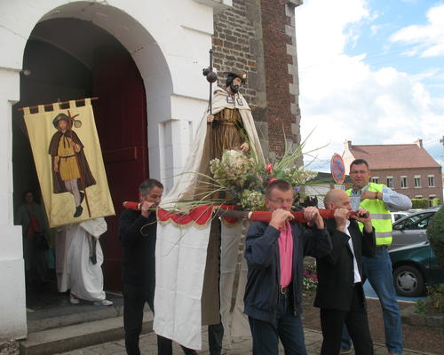 Au départ de l'église, derrière la CROIX du CHRIST suivie par la statue de Saint Roch, les pèlerins partent en chantant et en priant vers la chapelle où sont bénis les pains et quelques animaux.