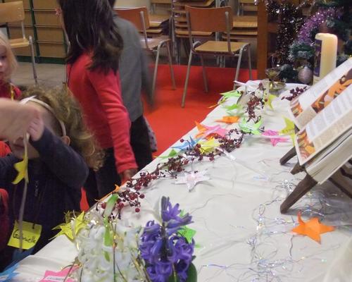 Ils viennent déposer, autour de la crèche, des étoiles qu'ils ont réalisées.