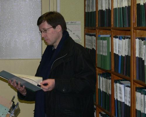 Christophe consulte le registre de son baptême.