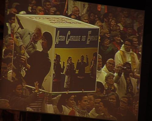 Des cubes portant des photos de personnes, des visages... arrivent de chaque extrémité de la basilique...