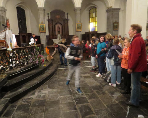 Des enfants et des adultes déposent leur prière dans la corbeille.