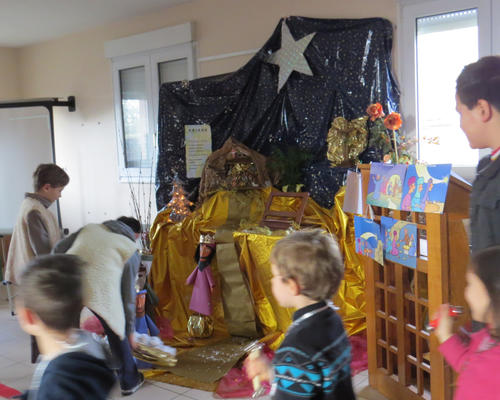On dépose les cadeaux offerts à Jésus, tout comme l'ont fait les rois mages.