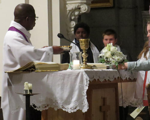 Hosties, calice, fleurs coupées sont posés sur la table eucharistique