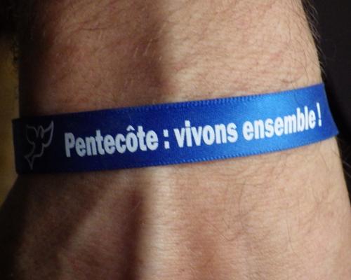 bracelets distribués à l'entrée de l'église aux couleurs des 3 diocèses en synode (bleu, rouge et orange)