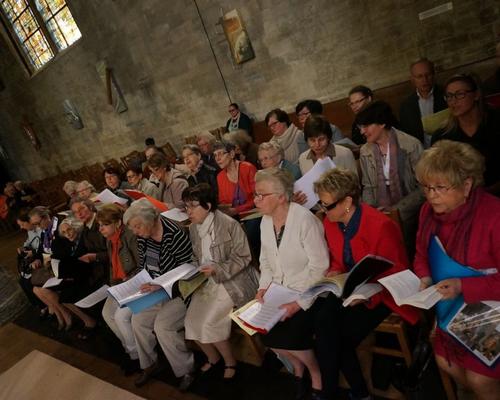 Servir ; La chorale est prête, la messe va pouvoir commencer.