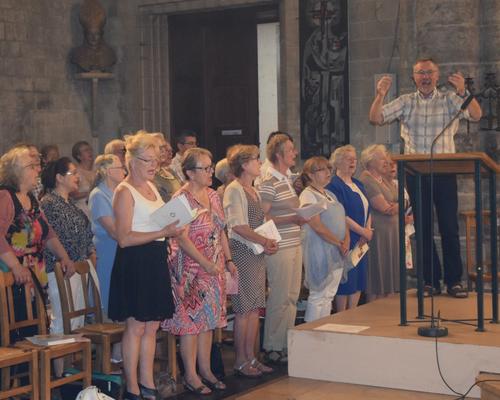 Bernard dirigeant une chorale attentive et joyeuse