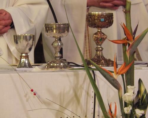 Calice et ciboires sur la table eucharistique.