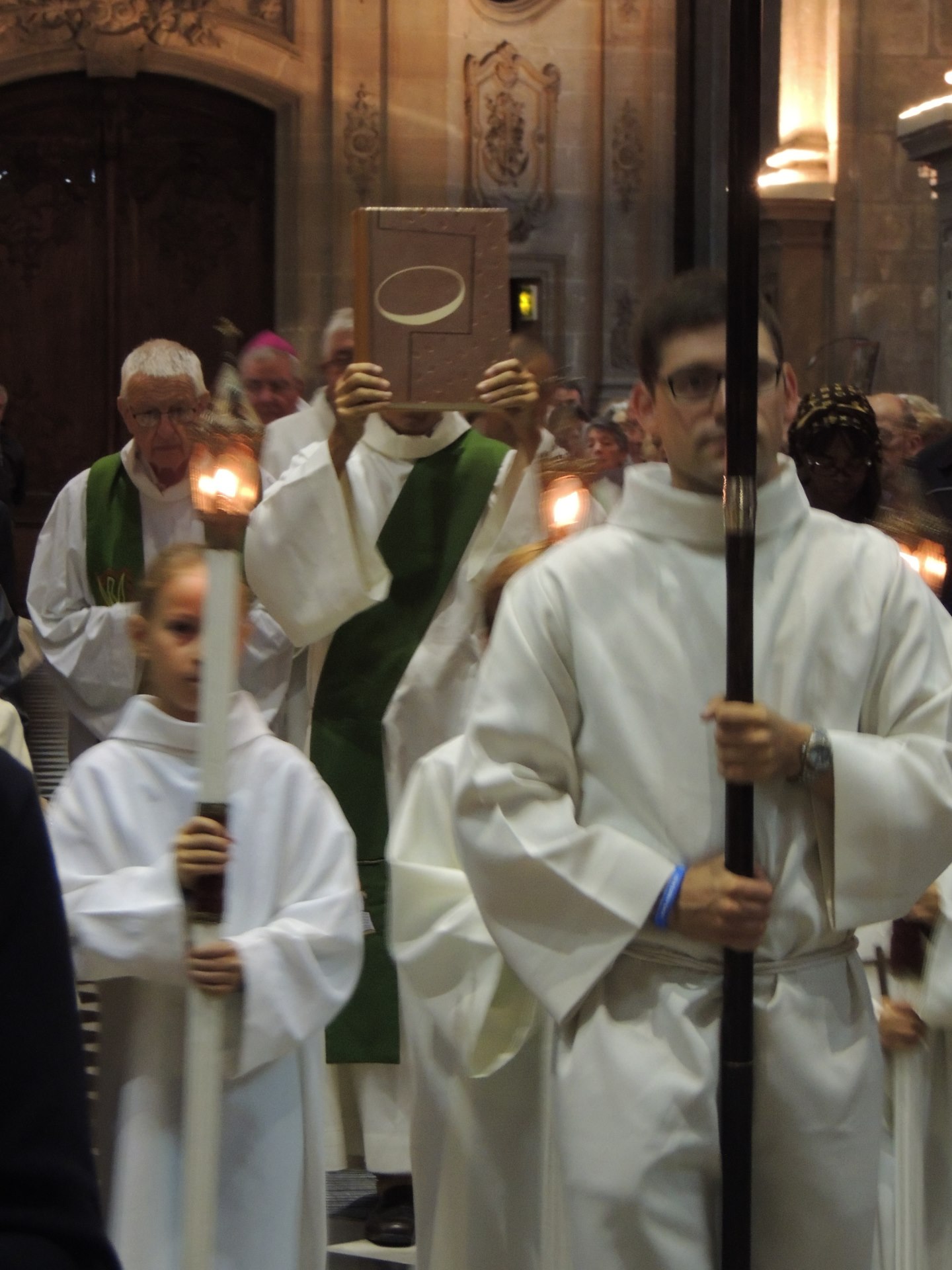 Maxence, séminariste, porte la croix de procession