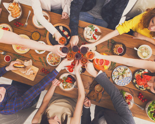 People say cheers clink glasses at festive table d