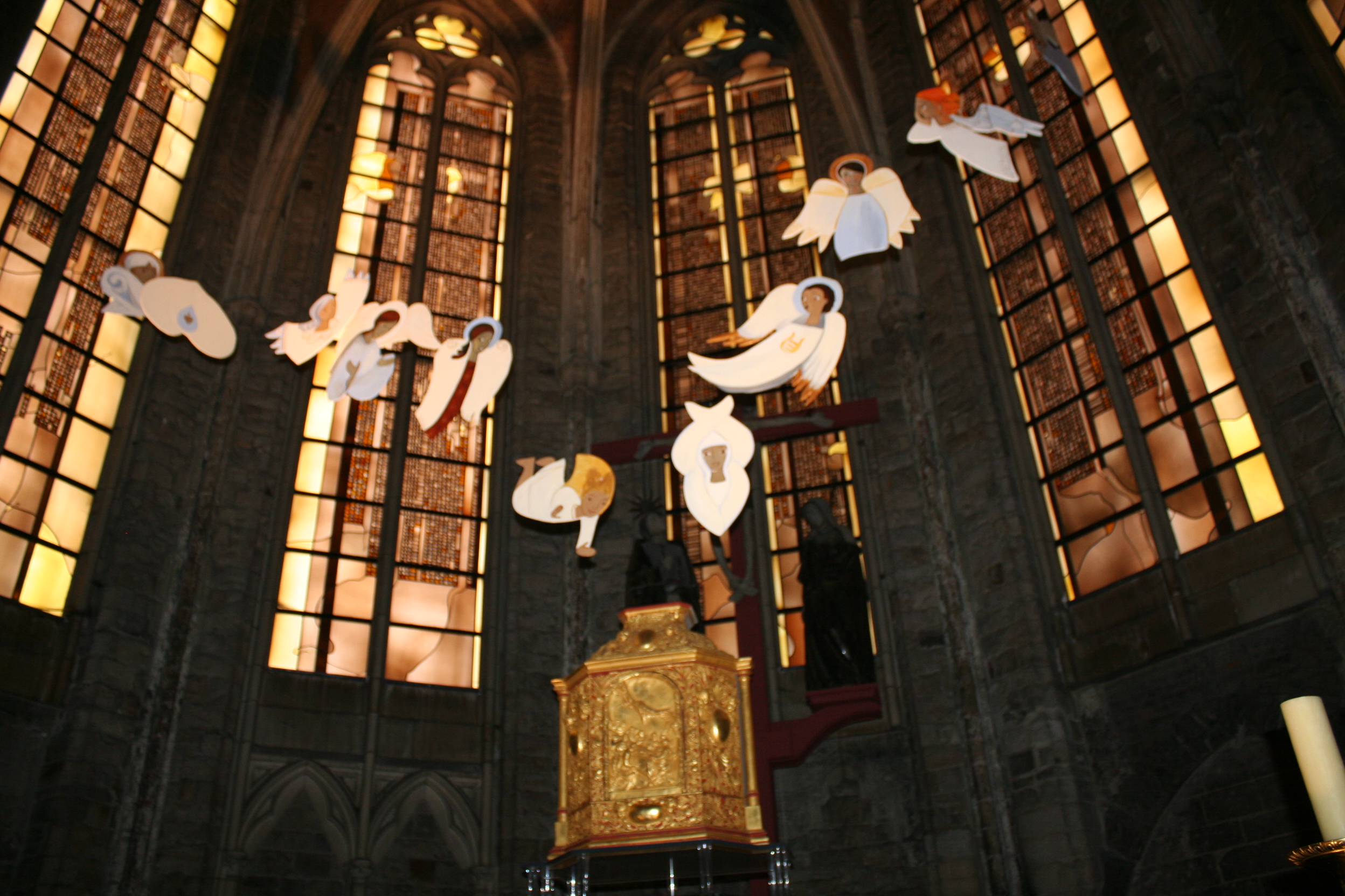 Au-dessus du tabernacle et devant le calvaire, volent de nombreux anges...