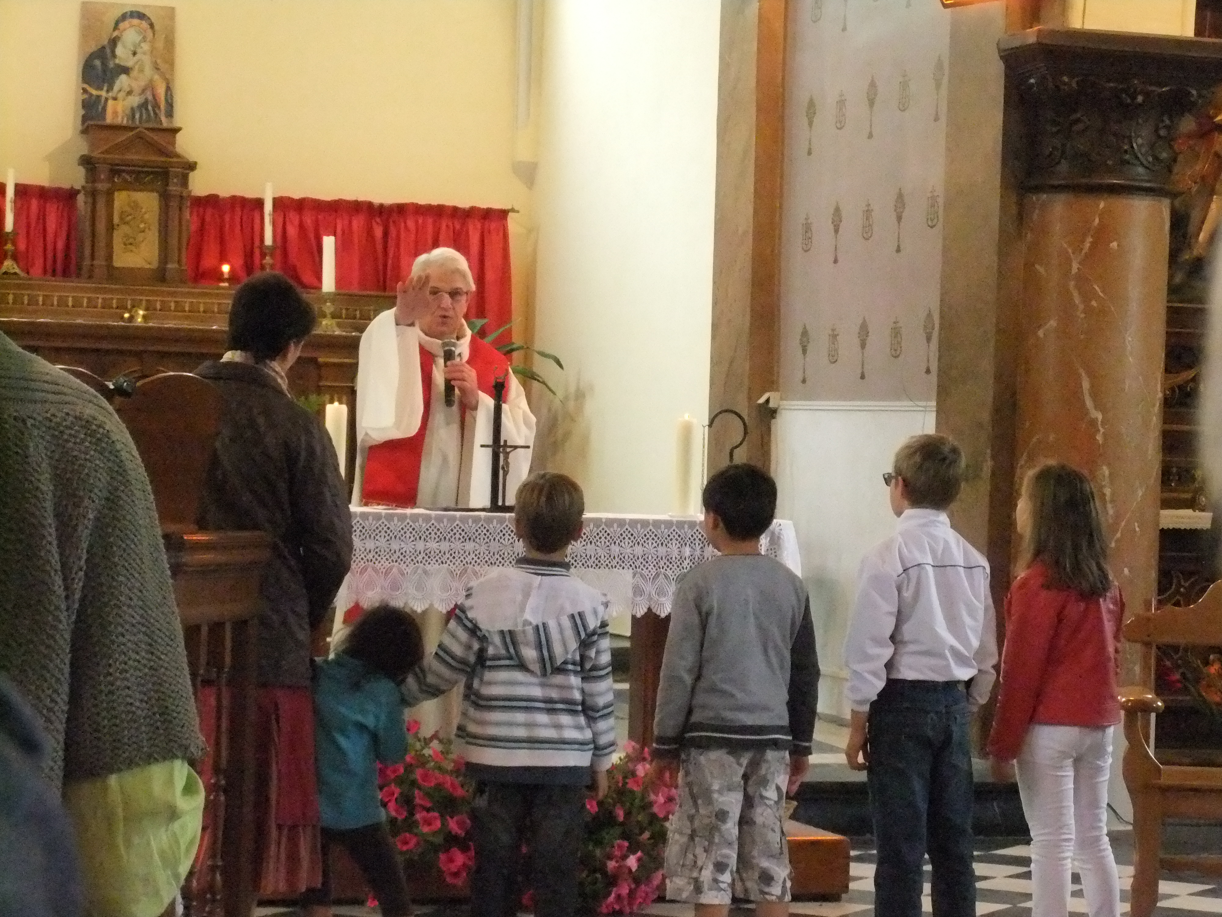 Réunis devant l'autel, les enfants reçoivent la benediction de l'Abbe JP JETTE  en fin de messe