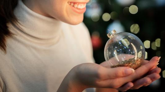 gros-plan-femme-smiley-tenue-globe-pour-arbre-noel