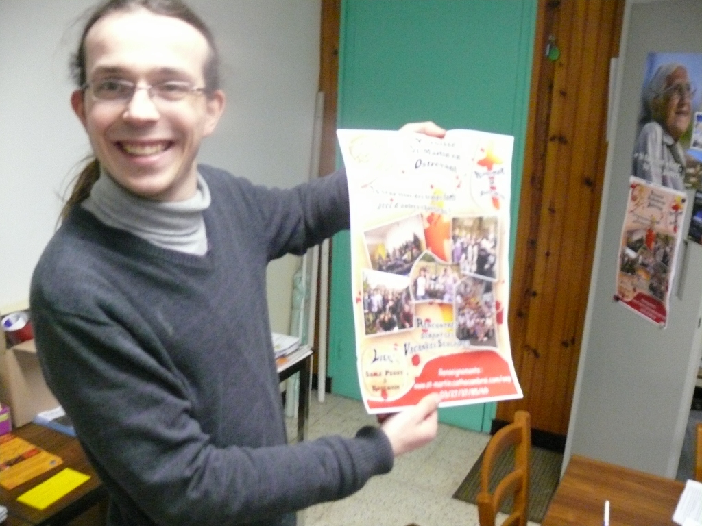 Jean-François, animateur, présente l'affiche "pub" de l'aumônerie